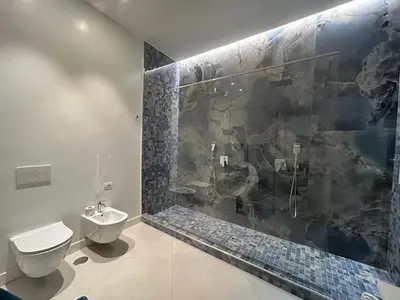 a bathroom with a toilet and a glass shower at A 2 passi da Piazza di Spagna in Rome