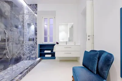 a bathroom with a blue chair and a shower at A 2 passi da Piazza di Spagna in Rome