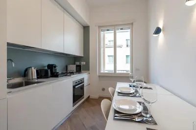 a kitchen with white cabinets and a table with wine glasses at [15 minutes from the centre] Free Wi-Fi & A/C in Rome