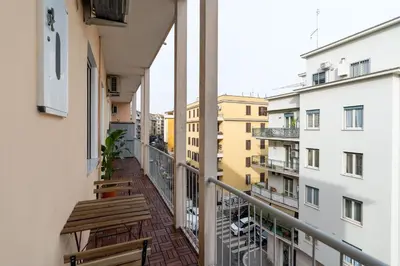 a balcony with two wooden benches and buildings at [15 minutes from the centre] Free Wi-Fi & A/C in Rome