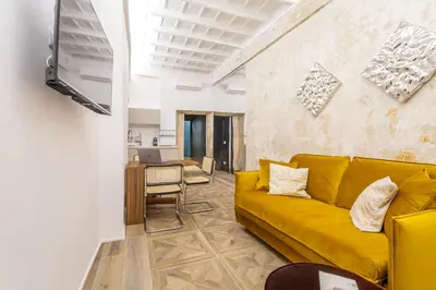a living room with a yellow couch and a table at Daplace - Elena Apartment in Rome