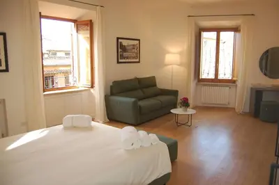 a bedroom with a large bed and a couch at Nesty Margana House in Rome