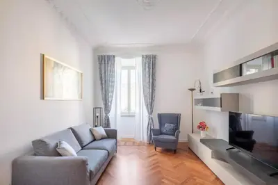a living room with a couch and a tv at Appartamento “La Palma nel Cortile” in Rome