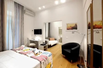 a bedroom with a bed and a chair in a room at Sofia's Suites Guesthouse in Rome