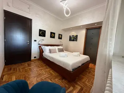 a bedroom with a bed and a blue chair at LUXURY AV in Rome