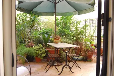 a table and chairs under an umbrella on a patio at Vacanze Romane in Rome