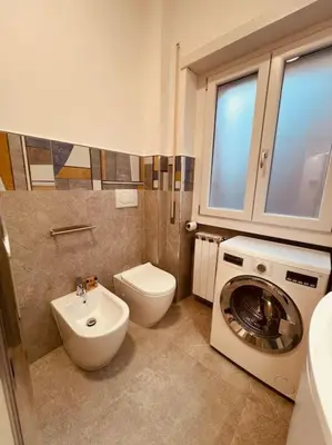 a bathroom with a toilet sink and a washing machine at 15 Min. Colosseo 1 - Casa di Giò in Rome