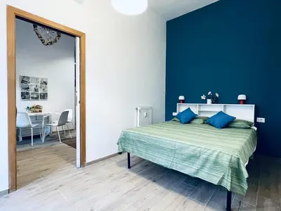 a bedroom with a bed with blue walls and a mirror at San Lorenzo 47 Loft in Rome