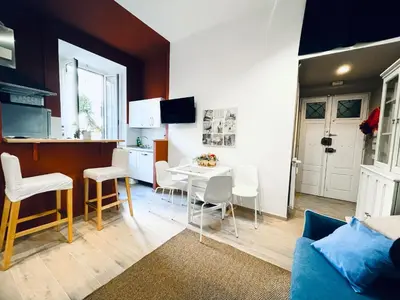 a kitchen and a living room with a table and chairs at San Lorenzo 47 Loft in Rome