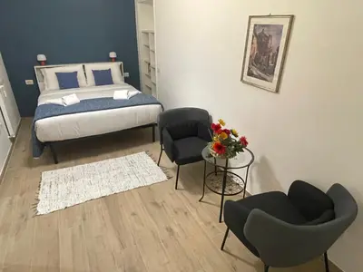 a bedroom with a bed and two chairs and a table at San Lorenzo 47 Loft in Rome