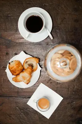a table with a cup of coffee and a plate of pastries at Domus Vitra 23 in Rome