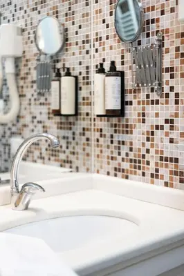 a bathroom sink with three bottles of soap at Domus Vitra 23 in Rome