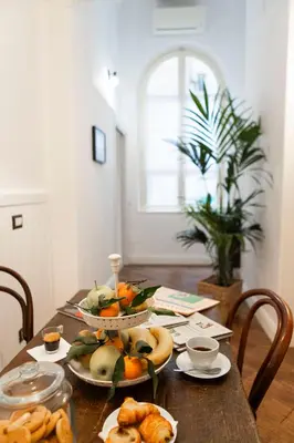 a table with plates of fruit and bread on it at Domus Vitra 23 in Rome