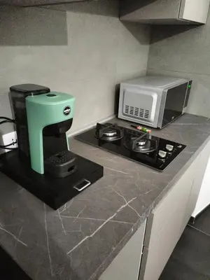 a kitchen with a coffee maker and a microwave on a counter at Azzurra Guest House Vaticano in Rome
