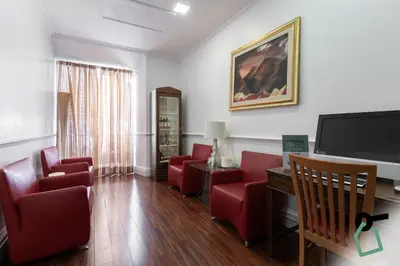 a living room with red chairs and a flat screen tv at HOTIDAY Room Collection - Roma Porta Pia in Rome