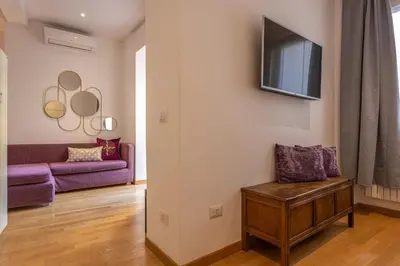 a living room with a couch and a tv on a wall at Colosseum Oasis in Rome