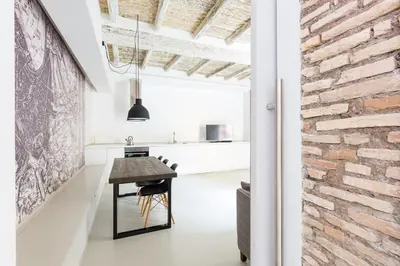 a kitchen with a table and a brick wall at Campo 13 Holiday Apartment in Rome
