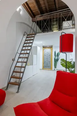 a red couch in a room with a staircase at Lovely studio Apartment - Capocci in Rome