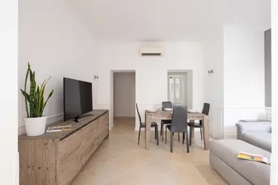 a living room with a table and a tv at Via Vespasiano Private Apartment in Rome