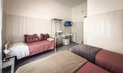 a bedroom with two beds and a tv in it at Hotel Giada Roma in Rome