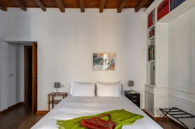 a bedroom with a white bed with a green towel on it at iFlat Classic And Contemporary Home in Rome