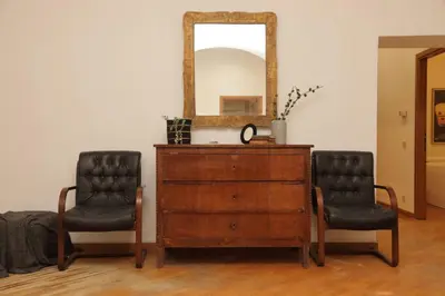 a dresser and two chairs next to a mirror at Giant Borghese Apartment in Rome