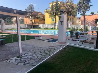 a swimming pool with a lighthouse next to a building at Domus Aurelia Studio Apartments in Rome