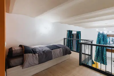 a bedroom with a bed and a balcony with blue curtains at Modern loft in central Rome in Rome