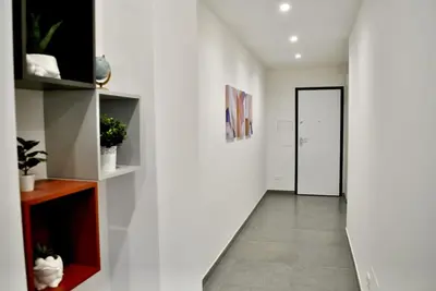 a hallway with a white wall and a door at White Mary House for two people in Rome