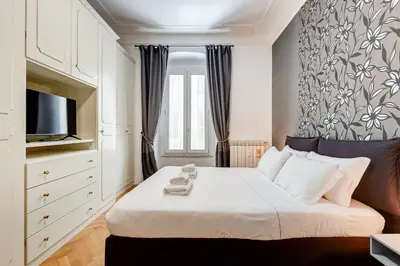 a bedroom with a large bed with a tv on it at Salotto Trastevere in Rome
