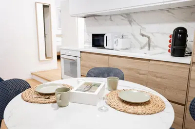 a kitchen with a table with plates and a microwave at Residenza Lungotevere dei Mellini in Rome