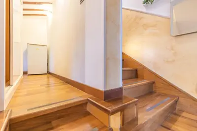 a hallway with wooden floors and stairs with a column at AC21 - Panoramic Studio in Rome