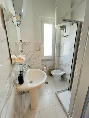 a white bathroom with a sink and a toilet at Il Nido apartment Roma, Attico ostiense in Rome