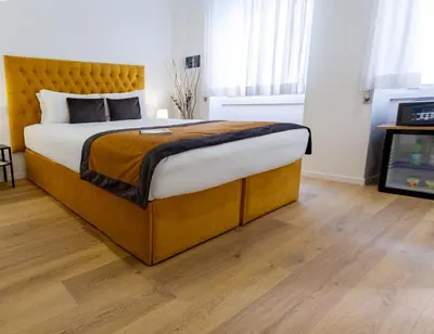 a bedroom with a large bed with a wooden headboard at Michelangelo Vatican Rooms in Rome