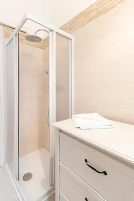 a bathroom with a shower and a white dresser at Hostly - Michelangelo Suite Midtown-Center of Rome in Rome