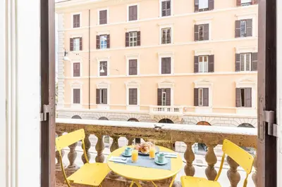 a table and chairs on a balcony with a building at Hostly - Michelangelo Suite Midtown-Center of Rome in Rome
