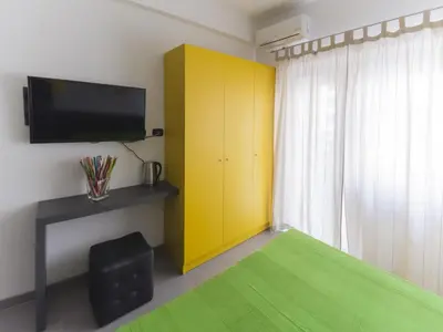 a bedroom with a yellow cabinet and a green rug at Affittacamere Tiburstation 2 in Rome