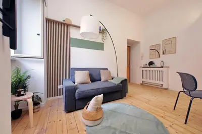 a living room with a blue couch and a table at Gazometro Apartment SelfCheck-in in Rome
