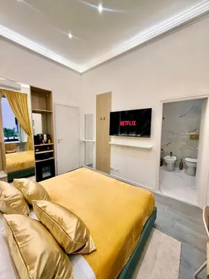 a hotel room with two beds and a television at San Pietro Suite - Vatican City in Rome