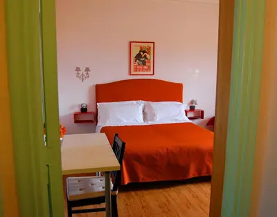 a bedroom with a bed with an orange blanket at Colosseoinn in Rome