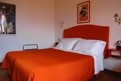a bedroom with a bed with an orange blanket at Colosseoinn in Rome