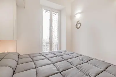 a white room with a large mattress in front of a window at Trastevere House 24 in Rome