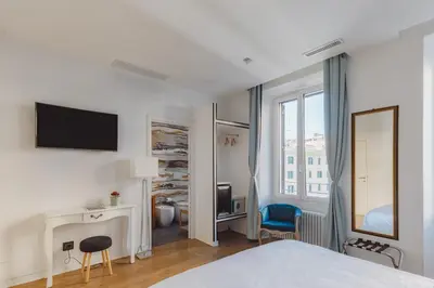 a bedroom with a bed and a desk and a tv at The Place Giuliana in Rome