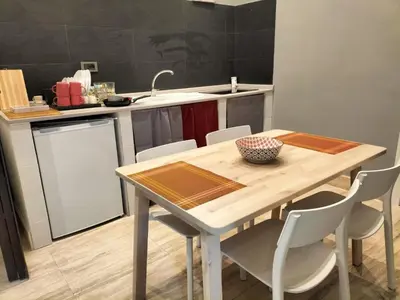 a kitchen with a wooden table with chairs and a sink at OLD BAKERY TWO BED ROOM APARTMENT in Rome