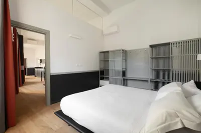 a bedroom with a large white bed and shelves at Trastevere Charming Rosa Apartment in Rome