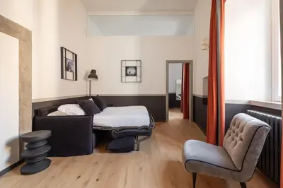 a bedroom with a bed and a chair at Trastevere Charming Rosa Apartment in Rome