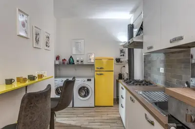 a kitchen with a washing machine and a yellow refrigerator at Kira Luxury Apartment with terrace in Rome