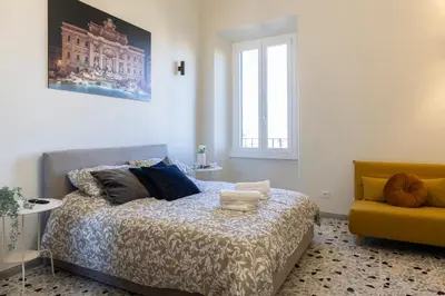 a bedroom with a bed and a yellow chair at A due passi dal Colosseo in Rome