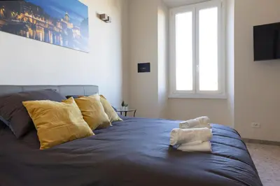 a bedroom with a blue bed with yellow pillows at A due passi dal Colosseo in Rome