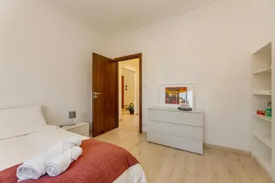 a white bedroom with a bed and a dresser at Italia Room vicino Stazione Termini in Rome